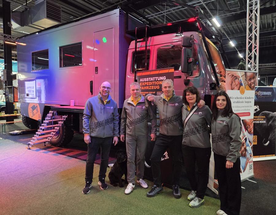 Team von Osterath vor dem umgebauten Expeditionsfahrzeug auf der Messe