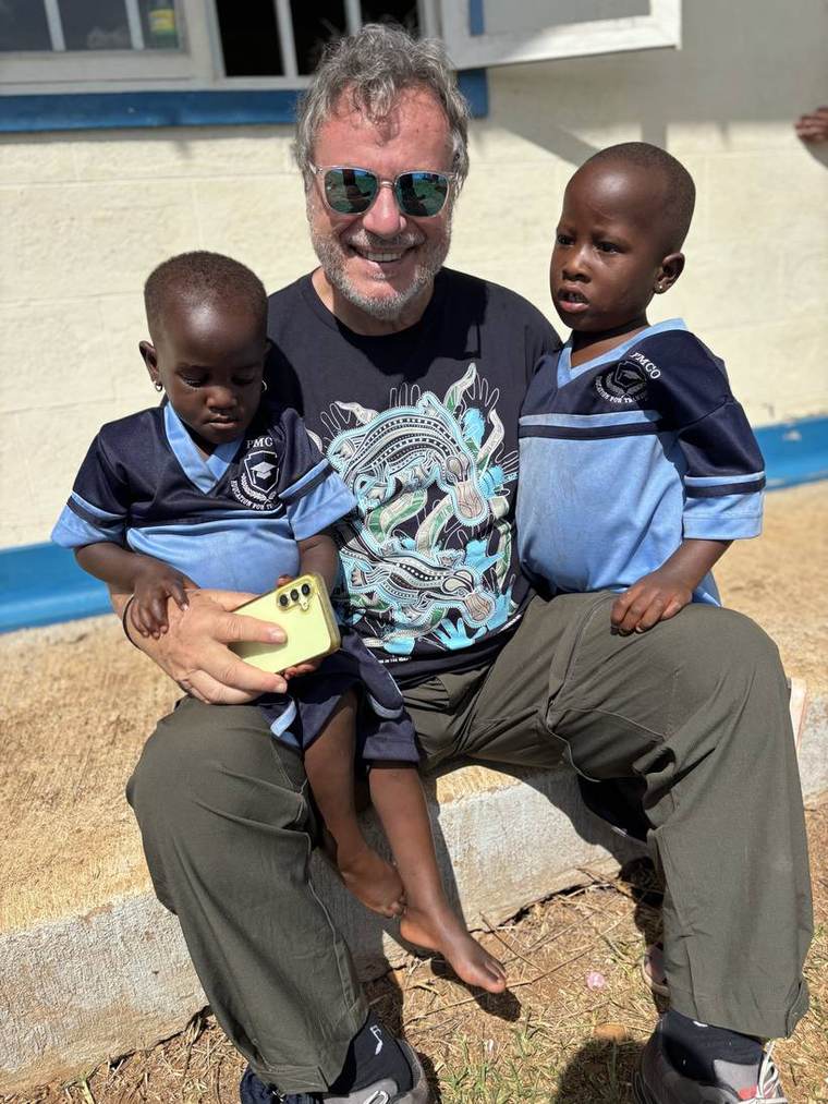 Teammitglied mit zwei Kindern vor dem Kindergarten