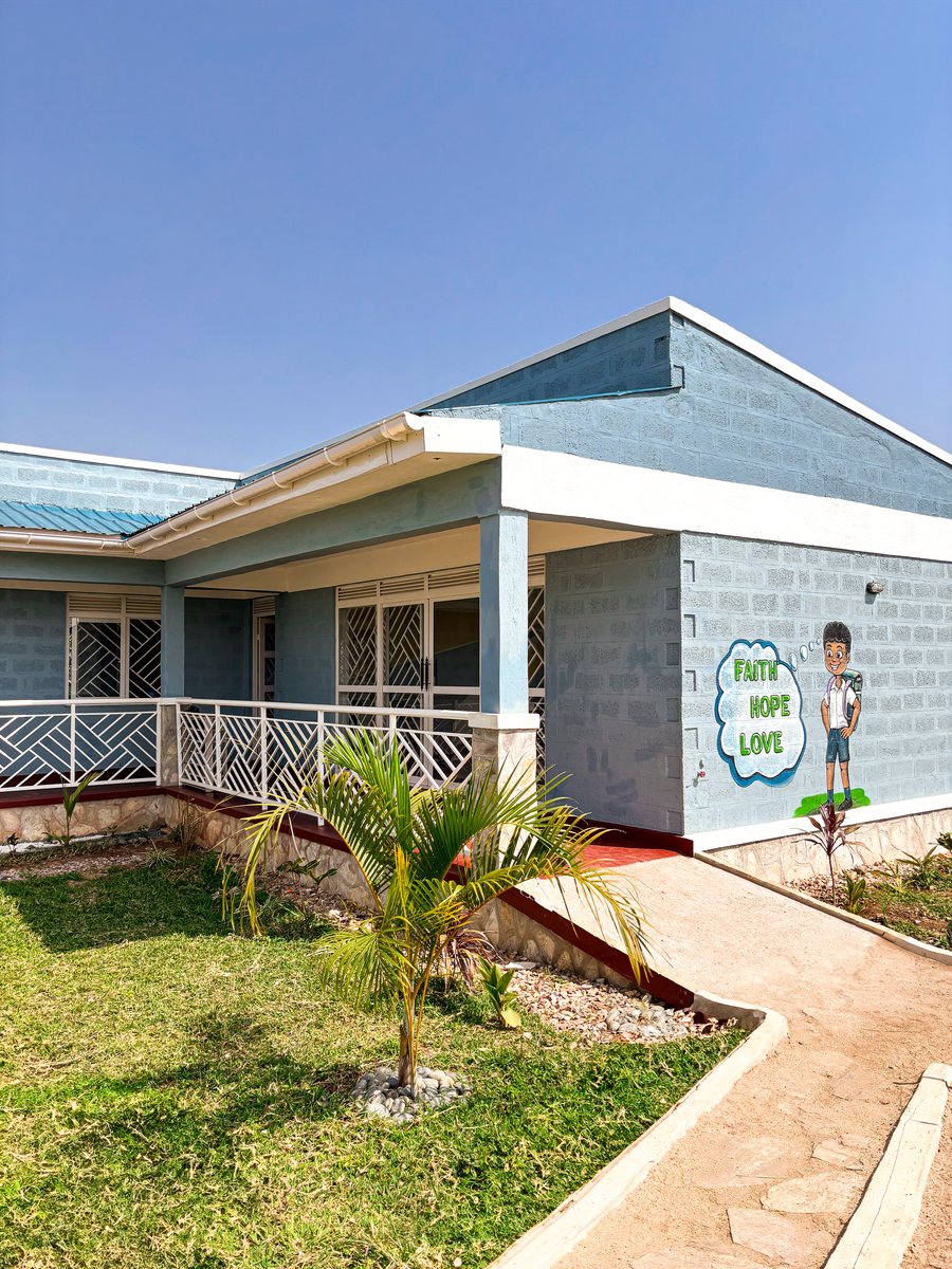 Das fertige Kindergartengebäude mit Veranda und dem Wandbild „Faith Hope Love