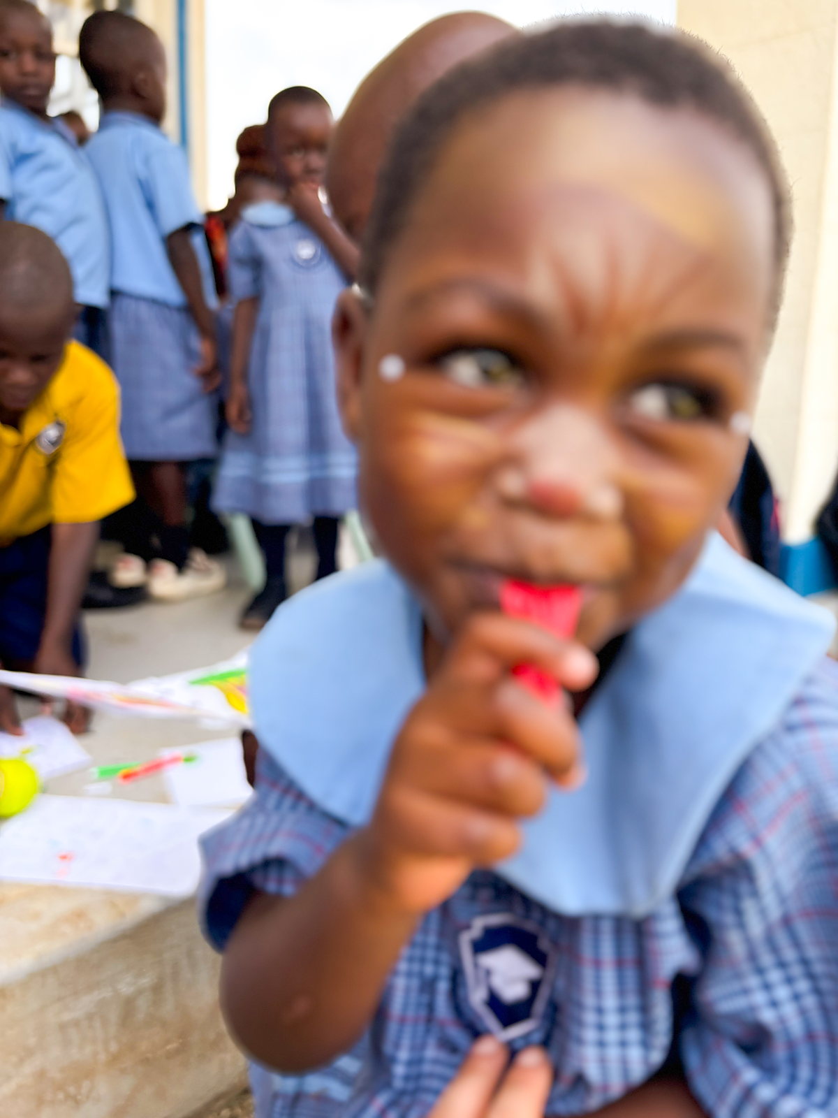 Kind im Kindergarten Mityana mit einem Eis am Stiel