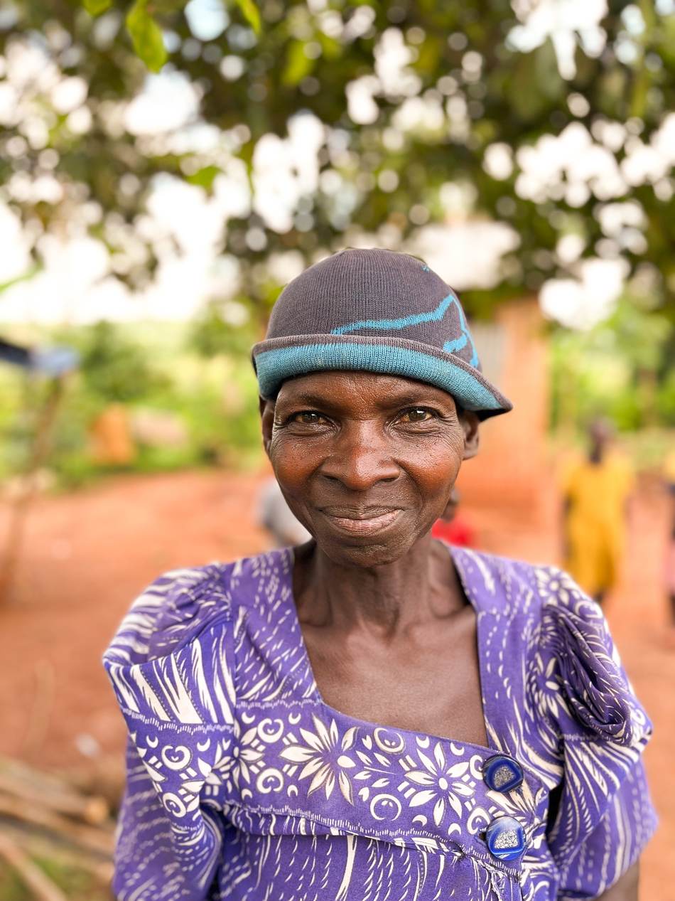 Lächelnde ältere Frau mit gemusterter Mütze in Uganda