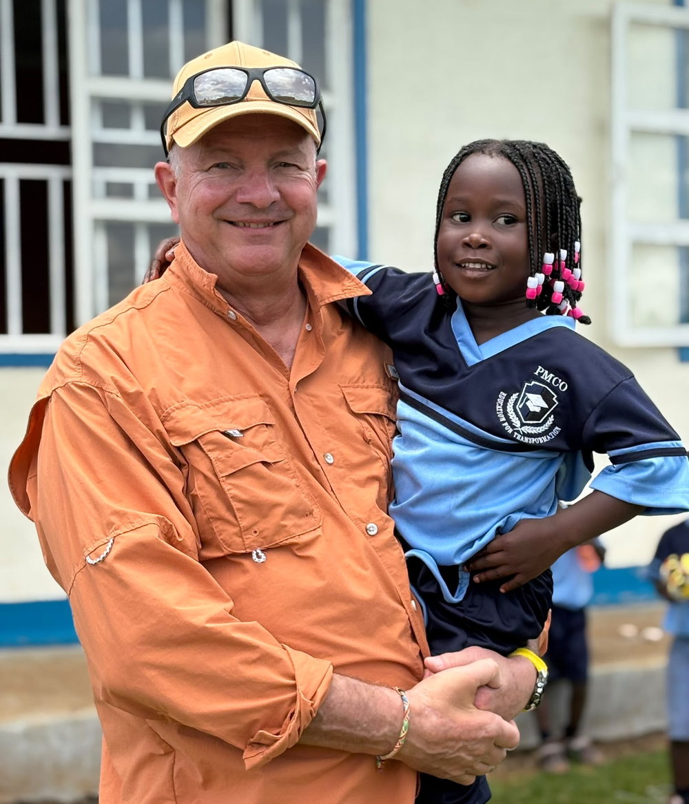 Teammitglied der Jona Foundation mit einem Mädchen der PMCO-Schule in Mityana