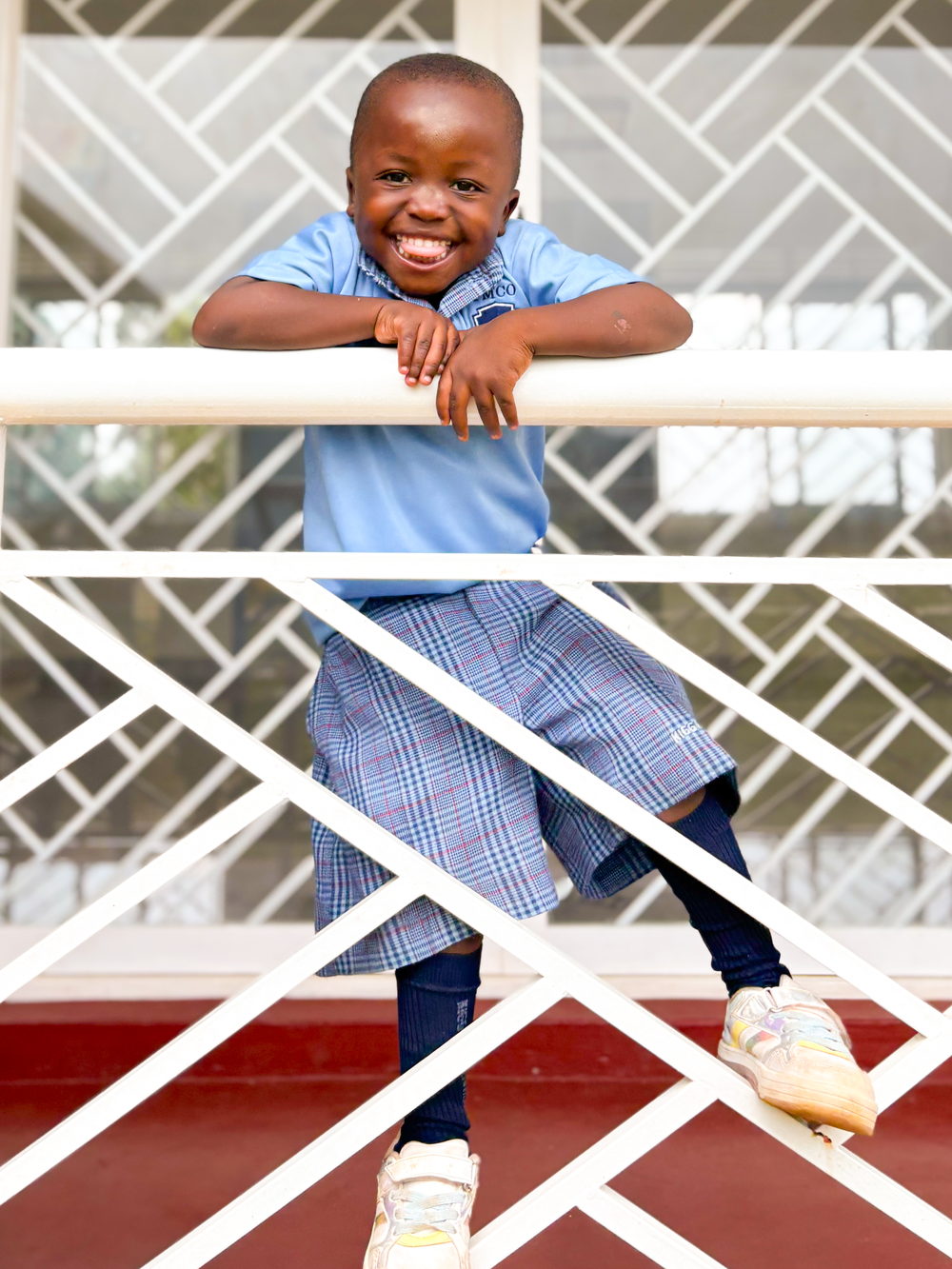 Junge im Kindergarten Mityana an der Brüstung des fertigen Gebäudes