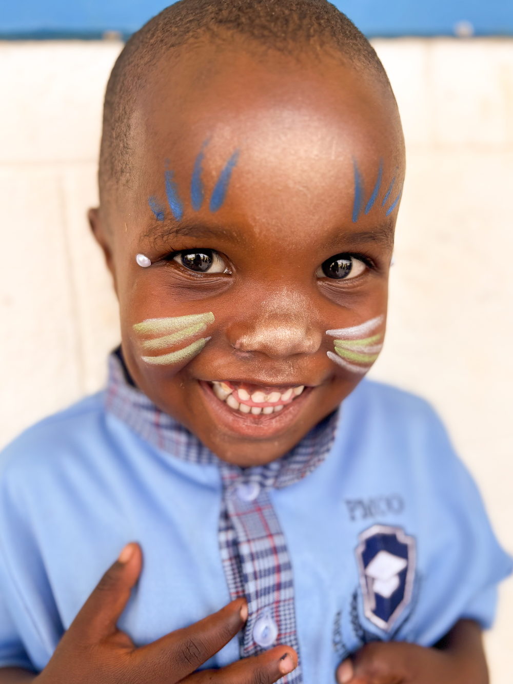 Lachender Junge mit bemaltem Gesicht im Kindergarten Mityana